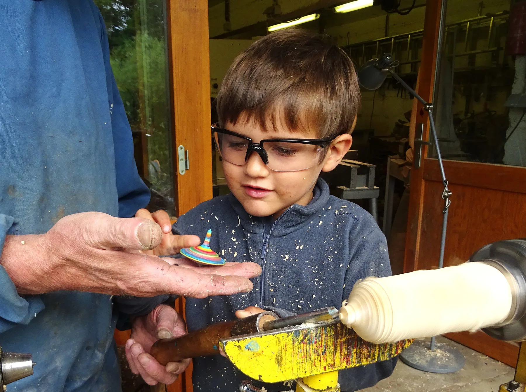 Enfant fier de sa toupie tout juste tournée en bois